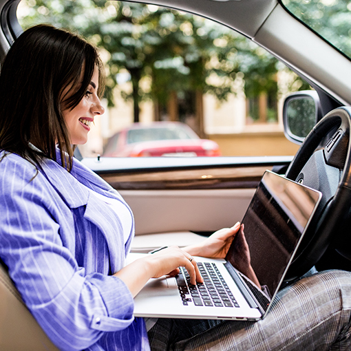 kobieta pracująca na laptopie w samochodzie