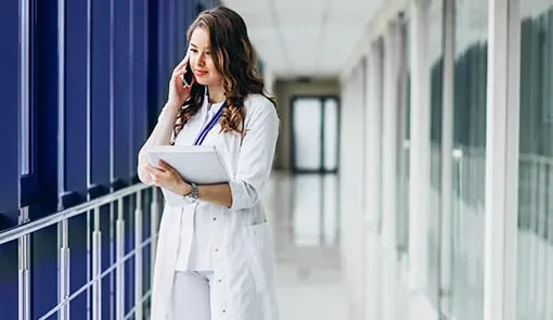 Proget zarządzanie mobilnością dla branży medycznej: doktor trzyma dokumentację i rozmawia przez telefon