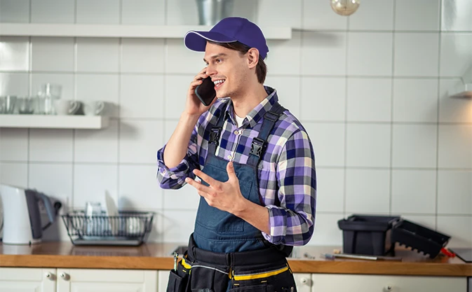 serwisant w domu klienta rozmawia przez telefon służbowy