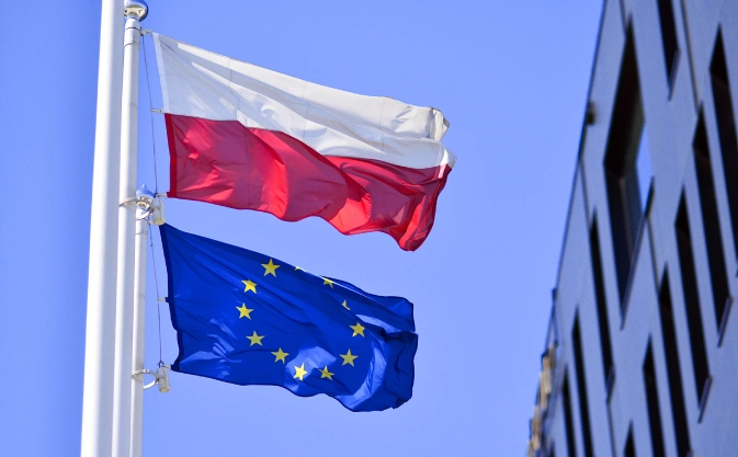 flagi Polski i Unii Europejskiej powiewające na maszcie