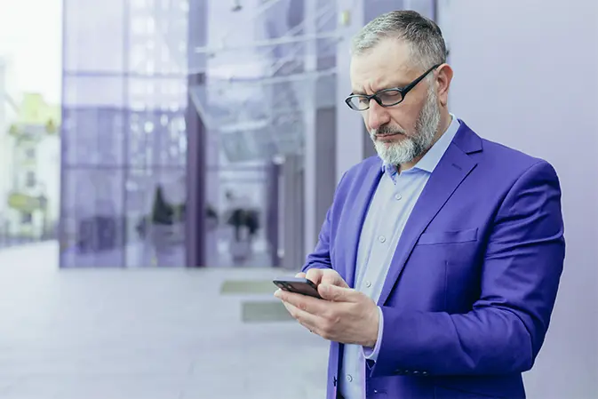 mężczyzna w garniturze używa smartfona