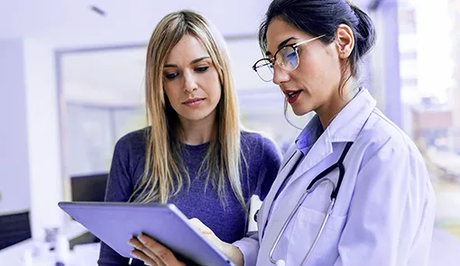 Proget zarządzanie mobilnością dla branży medycznej: doktor trzyma tablet i pokazuje pacjentowi wyniki badań