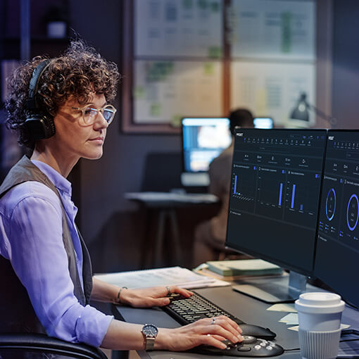 woman working at two screens with Proget console