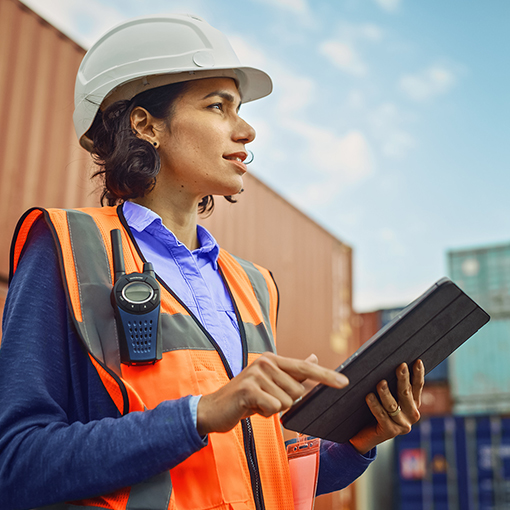 woman in work attire with ruggedized tablet
