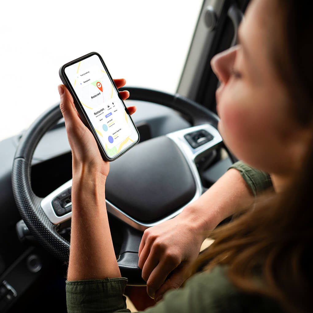 woman in car holds phone with navigation app