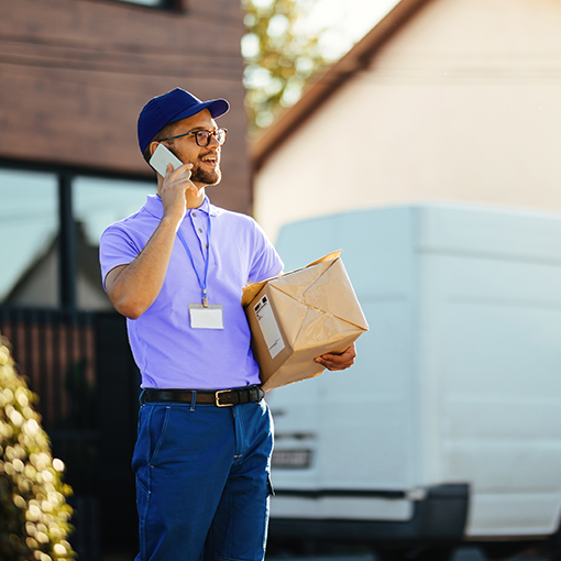 courier with a package talks on the phone
