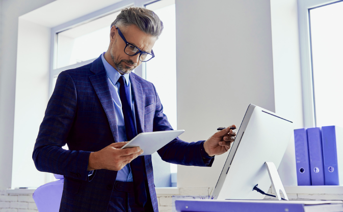 a businessman reviews documents on a tablet