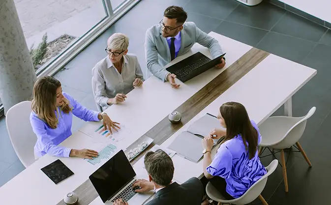 office staff at a business meeting, with laptops and tablets
